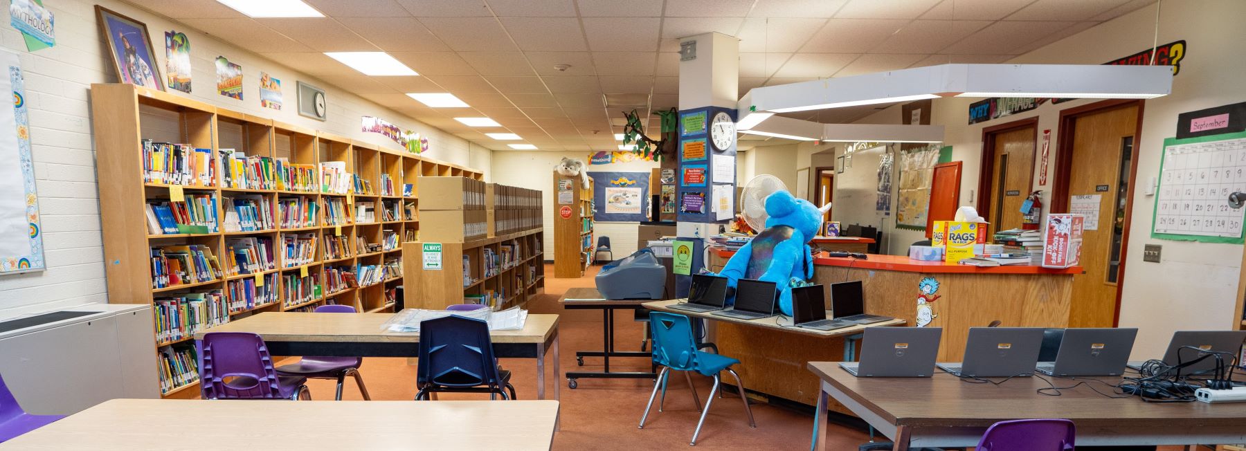 A spacious library filled with tables and chairs, perfect for studying and reading in a quiet environment.